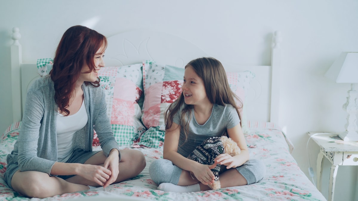 Mère dialoguant calmement avec sa fille, une réponse parentale clé face à l'addiction aux écrans