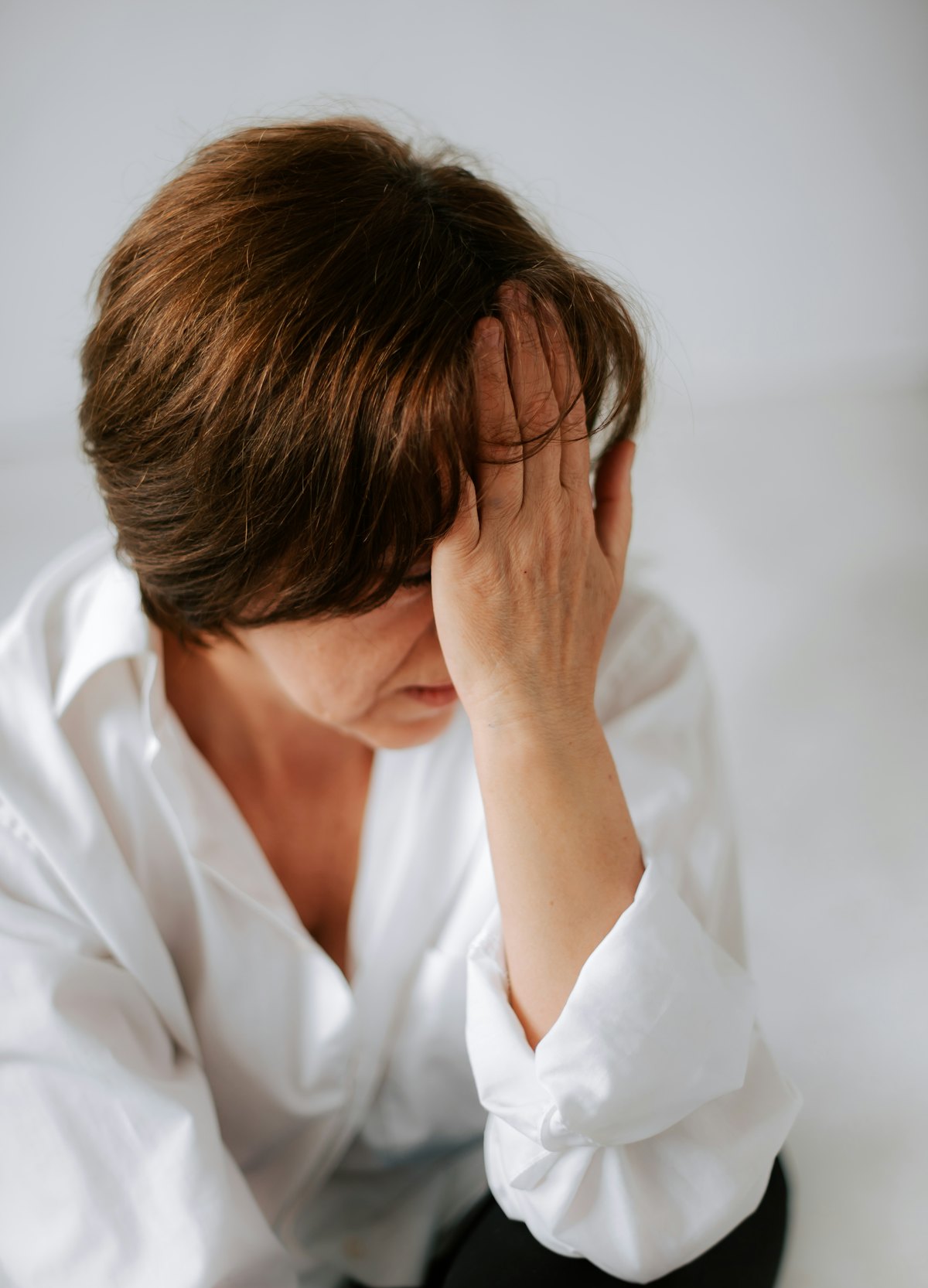 Signes de l'anxiété périnatale Symptômes de l'anxiété périnatale : jeune mère épuisée se tenant la tête