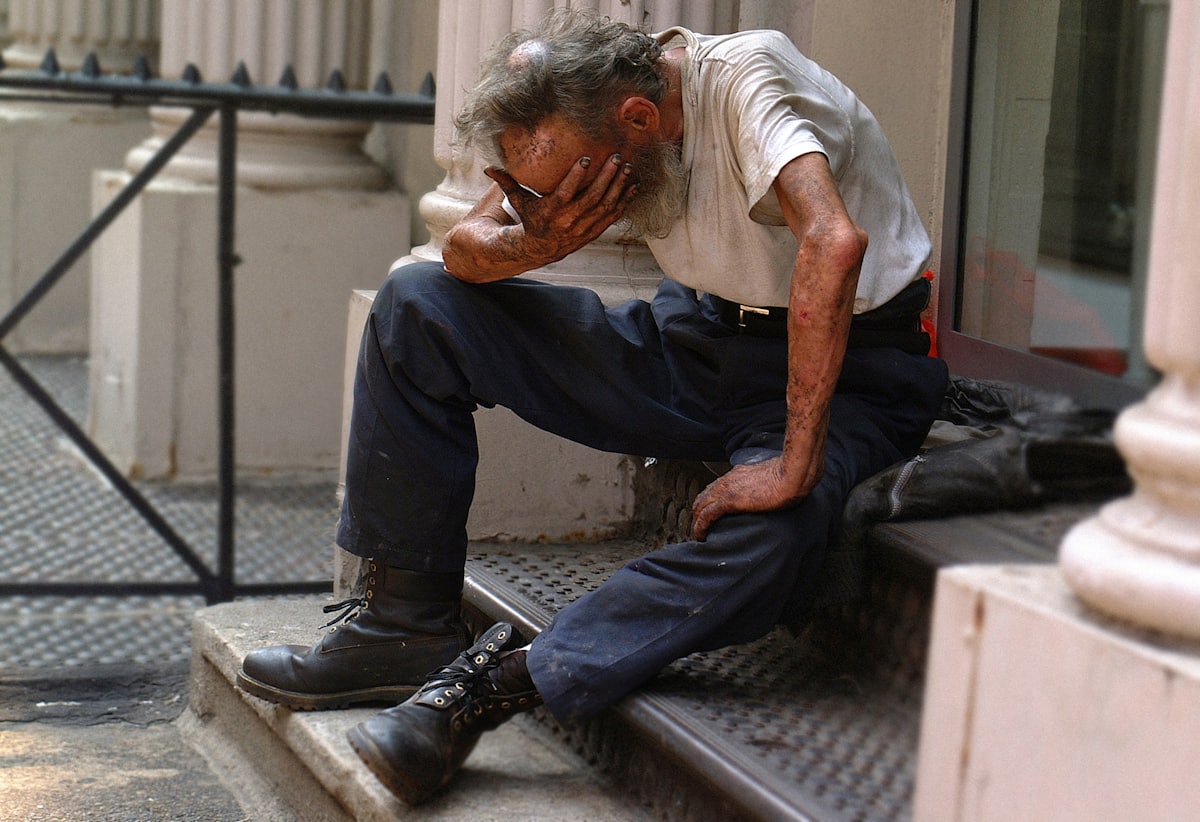 Symptômes du sevrage alcoolique Homme assis la tête entre les mains, illustrant la détresse ressentie pendant un sevrage alcoolique