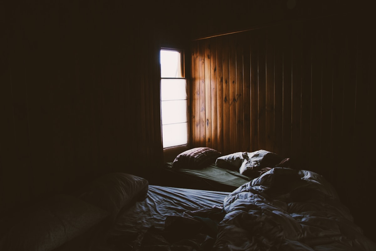 Nuit difficile et consultation Chambre sombre la nuit avec un lit, évoquant les cauchemars et le moment de consulter