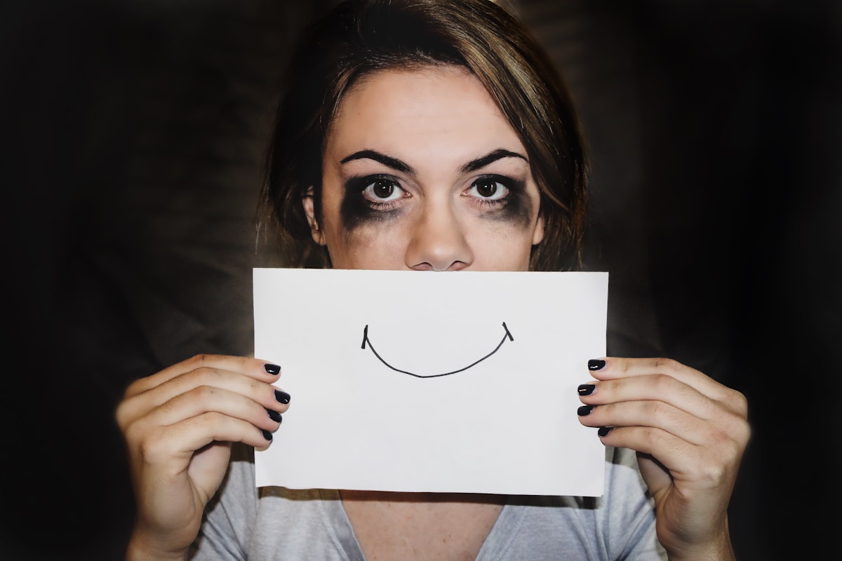 Le silence derrière le sourire Femme dissimulant sa souffrance derrière un sourire dessiné, illustration du tabou de la santé mentale