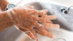 Lavage des mains au savon dans un lavabo, rituel répétitif évoquant le trouble obsessionnel compulsif (TOC)