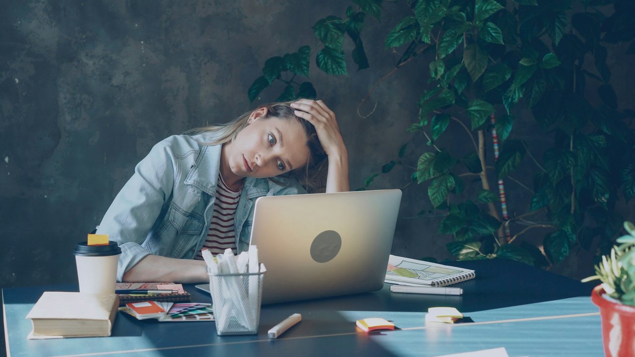 Étudiante épuisée devant son ordinateur portable, la tête dans la main : la santé mentale des étudiants mise à l'épreuve par le stress